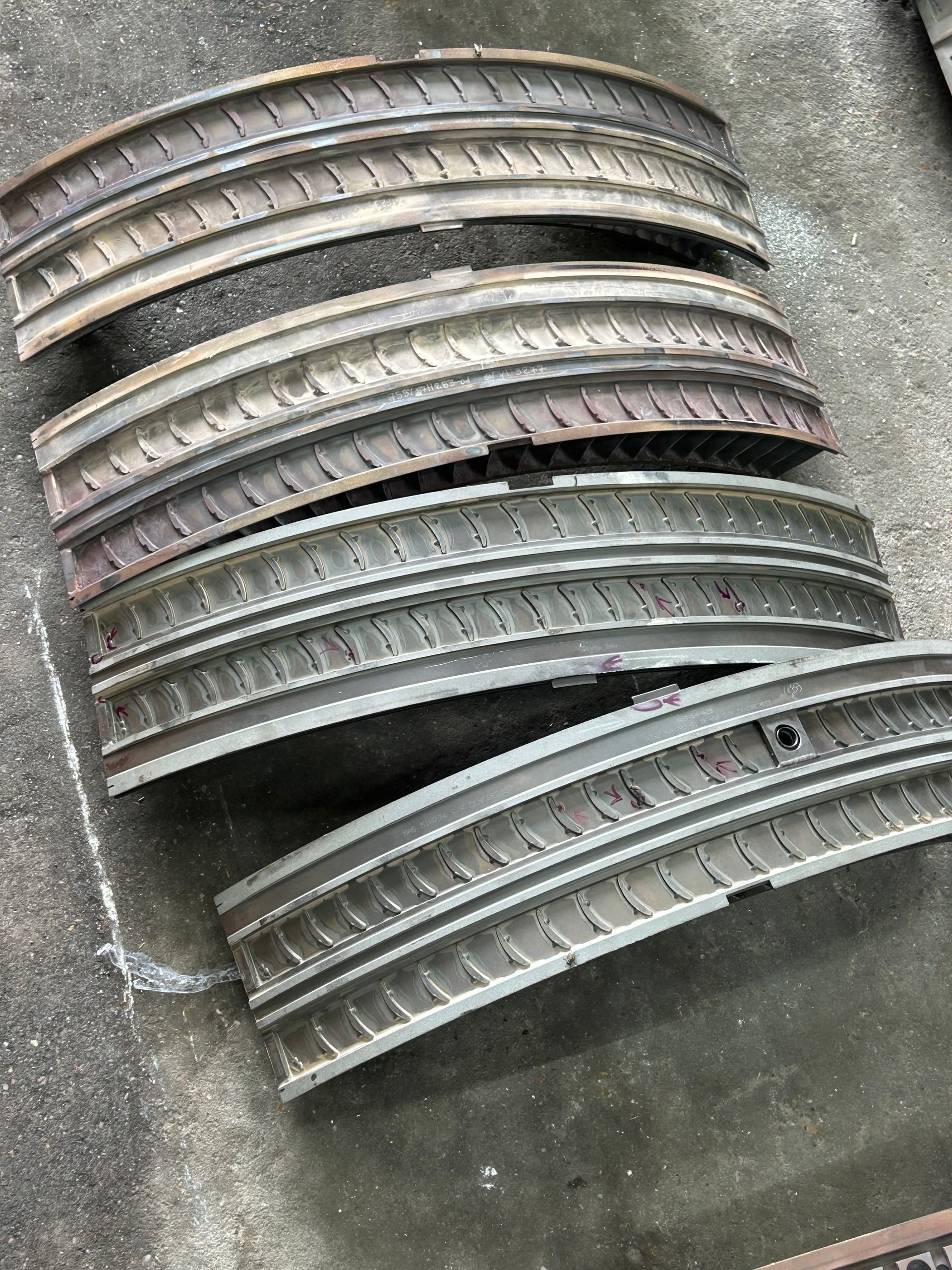 Rows of curved aircraft-engine vane assemblies